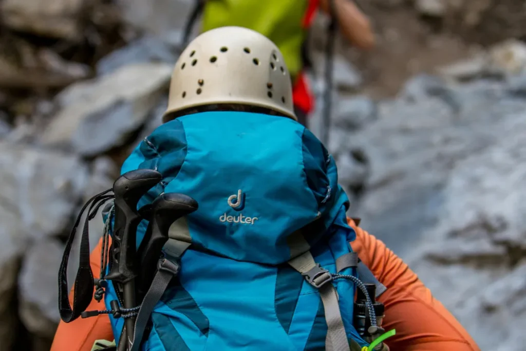 Una ragazza in escursione con uno zaino Deuter, marca che non usa PFAS durante la produzione dei suoi capi.